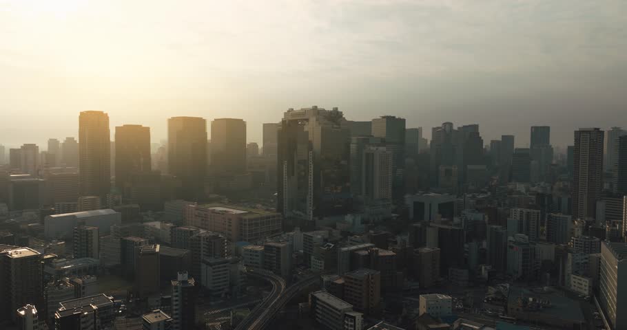 Aerial view of city skyline with skyscrapers, buildings, and urban architecture in Osaka City during sunrise. Osaka, Japan.