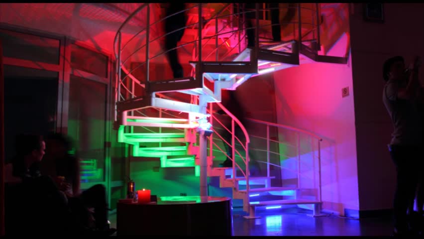 Timelapse of people going up the colorful stairs in night club