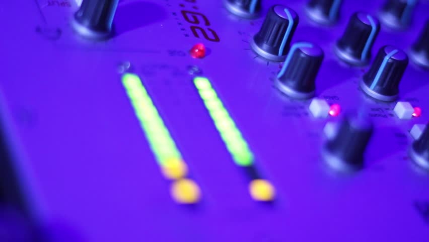 Audio levels on DJ's tool deck reach maximum sound loudness