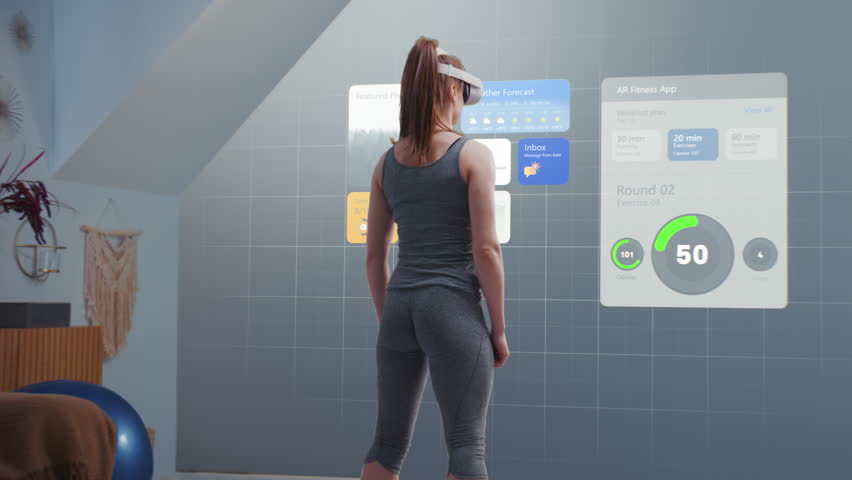 Athletic woman wearing AR headset starts online training. VR screen with displayed virtual coach and interface of fitness app with workout plan. Metaverse futuristic home gym with AI technologies.