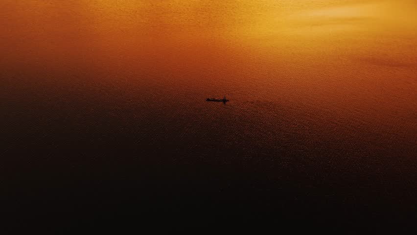 the boat sail lonely in middle of lake when sunrise or sunset. Aerial Drone 4K