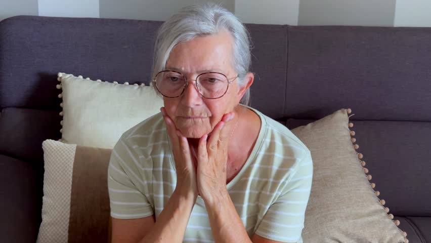 Thoughtful sad worried middle aged elder woman looking away think of loneliness grief sorrow concept, serious depressed old mature grandma lost in thought feel concerned alone at home, close up view