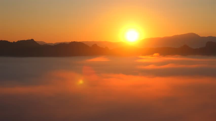 Serene sunrise with golden light illuminating misty mountain landscape in early morning. Beautiful horizon view with soft mist covering valleys. Capturing tranquility and beauty of nature.