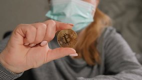 Woman wearing surgical face mask, holding bitcoin an innovative payment network and a new kind of money. The concept of protection against the financial crisis and economic recession.  - Powered by Shutterstock - Get 15% off with code: PIKWIZARD15