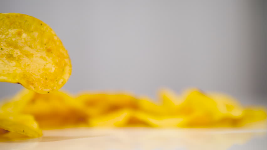 A man eats potato chips with white garlic sauce. Dip chips in sweet mayonnaise sauce. Slow motion