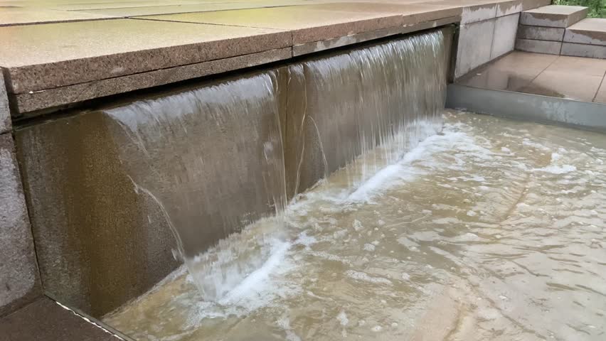 An artificial waterfall flows in a steady stream in the park