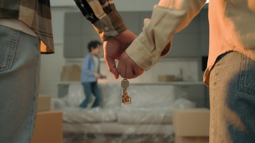 Couple hands bonding woman man holding keys of new home own house moving day relocation happy child kid boy son jump couch celebrate african american parents buy rent real estate credit loan mortgage