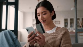 Caucasian hispanic smile woman hold credit card and smartphone happy female girl buyer shopper discount surprise mobile phone payment purchase online store shopping using bank app service pay at home - Powered by Shutterstock - Get 15% off with code: PIKWIZARD15