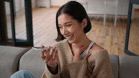 Happy joyful smiling Caucasian hispanic woman girl homeowner lady female user relax on home couch record audio message smartphone voice mail talking mobile phone speakerphone talk speak gossip laugh - Powered by Shutterstock - Get 15% off with code: PIKWIZARD15