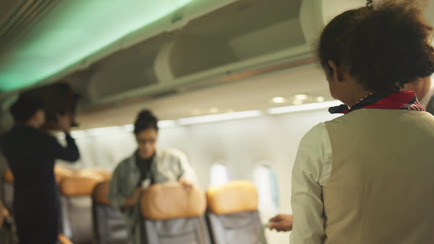 Air hostess stand in front of gate of airplane to welcome and service the customers before take of from airport.