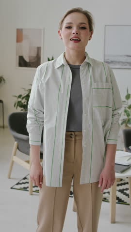 Medium vertical POV portrait of smiling deaf-mute Caucasian girl signing phrase, I love you, in ASL, with hand gesture, looking at camera