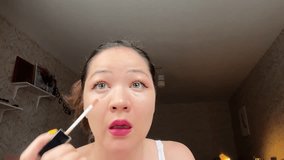 Close-up view of Korean girl using concealer to hide tiredness and lack of sleep. Asian make-up process. Chinese woman making up at home. film grain pixel texture. soft focus. blur. live camera. - Powered by Shutterstock - Get 15% off with code: PIKWIZARD15