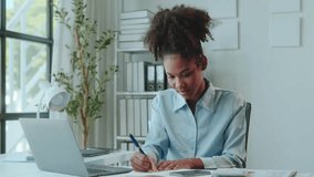 Professional woman working on laptop at office desk, focused and smiling. Modern office with natural light - Powered by Shutterstock - Get 15% off with code: PIKWIZARD15