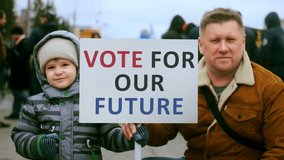 Presidential campaign for run office. Man activist hold protest our future banner with son. President elections political rally. Vote day. Voter people crowd riot city street. Elect us strike placard. - Powered by Shutterstock - Get 15% off with code: PIKWIZARD15