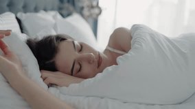 Serene woman resting in bed with morning light filtering through. Showing peacefulness and relaxation. Peaceful Woman Sleeping Comfortably in Bed with White Sheets in Cozy Bedroom - Powered by Shutterstock - Get 15% off with code: PIKWIZARD15