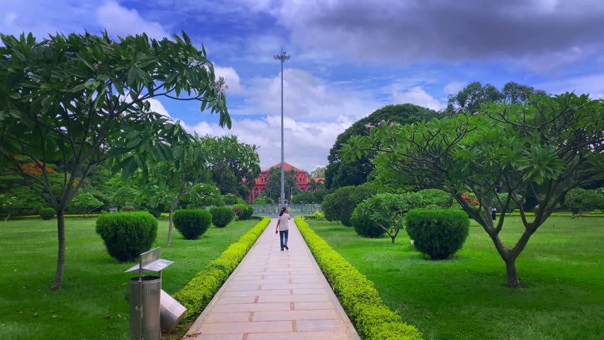 Young Indian woman relaxing and enjoying in cubbon park in a white shirt and jeans in Bangalore, india	