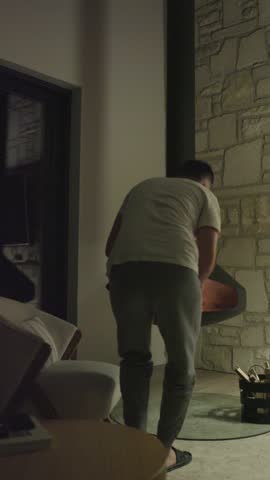 Urban Sanctuary. A man relaxing by the Fireplace, enjoying a cup of tea by the flames of the fire.