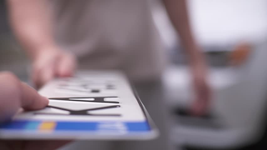 Buying a new car. The seller hands over the vehicle's license plate