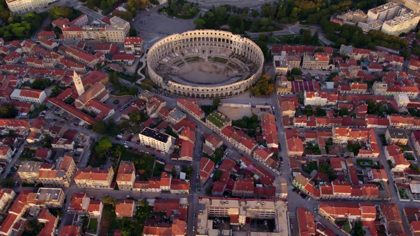 Aerial view of historic amphitheatre and city by the turquoise water in Pula, Istria, Croatia.