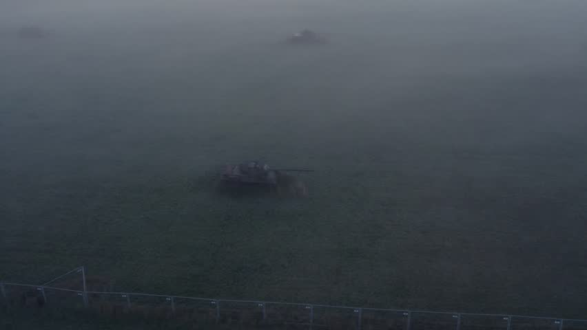 Aerial view of misty meadow with abandoned tanks during sunrise, Sogel, Lower Saxony, Germany.
