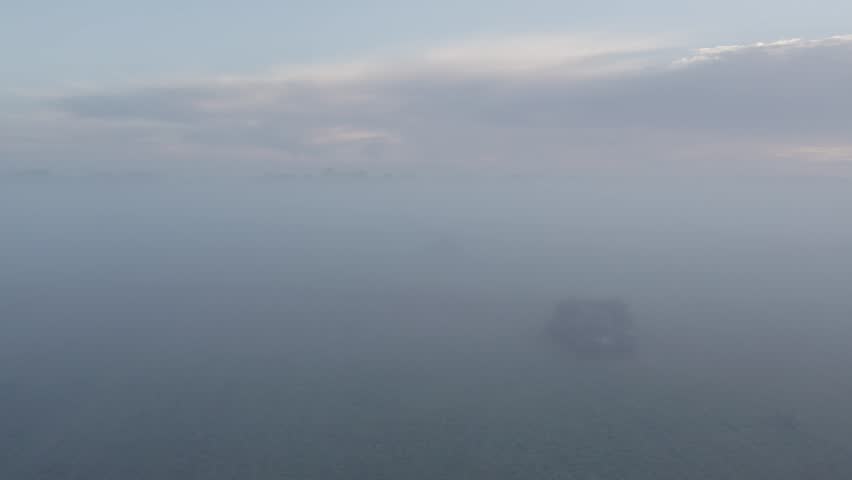 Aerial view of foggy meadow at sunrise with serene clouds and sky, Sogel, Lower Saxony, Germany.