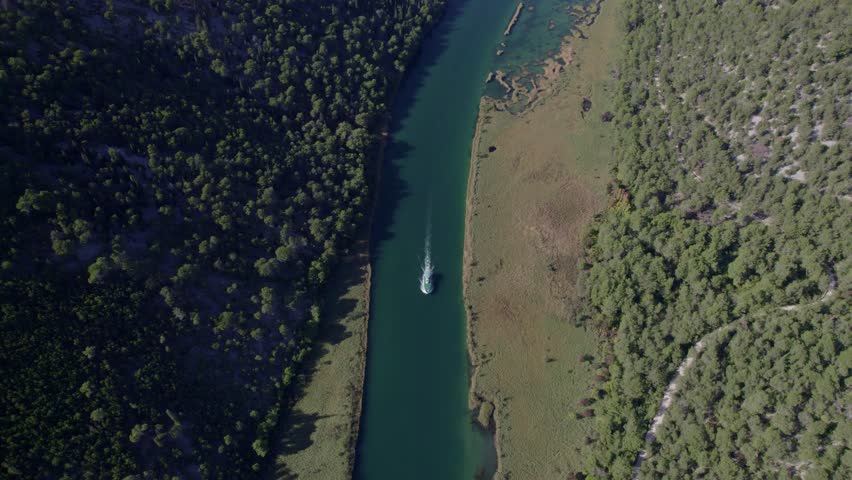 Aerial view of Krka National Park with river, boat, forest, and waterfall, Sibenik-Knin, Croatia.