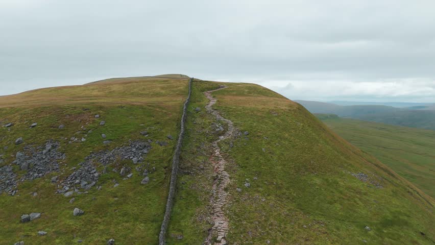 Aerial Trail hike patch dry stone wall, Lake District national park United Kingdom UK