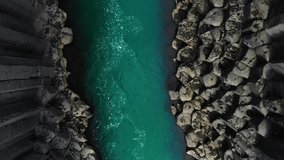 aerial top down view drone shot of basaltic rock formation, studlagil canyon,clean river water runs in the gorge,icelandic wild nature - Powered by Shutterstock - Get 15% off with code: PIKWIZARD15