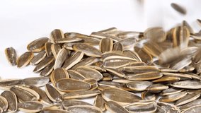 Dried Sunflower Seeds Falling on a Plate in Slow Motion Close Up. Top View. Background from Natural Products - Powered by Shutterstock - Get 15% off with code: PIKWIZARD15