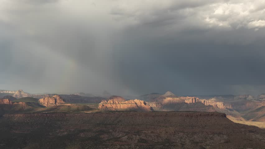 4k time lapse video of a summer thunderstorm and the formation of rainbows in the curtains of rain that passed over the mountains of Zion Nat. Park in Southern Utah, USA on July 20th 2024.