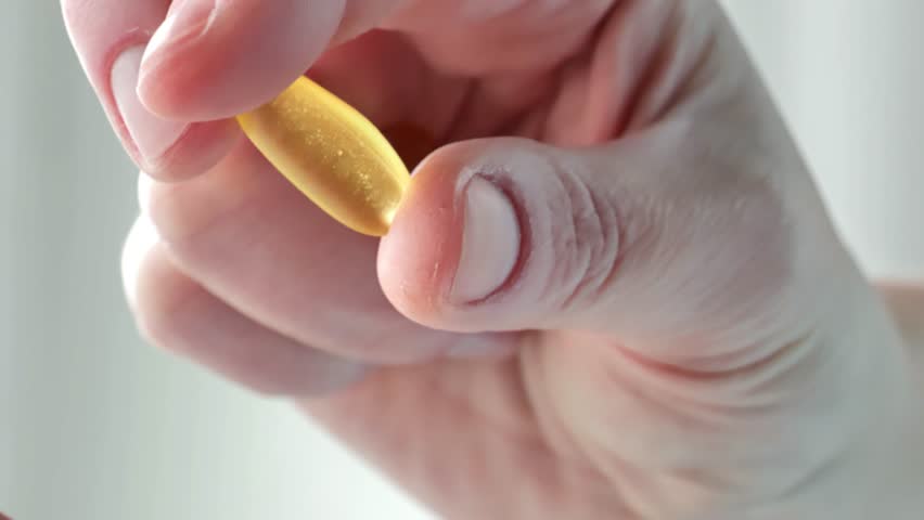 Fish oil capsules in female hands.Omega acid gelatin capsules . Healthy fats and womens health.Dietary supplements and vitamins in womens nutrition. Fish oil for womens health. 4k footage