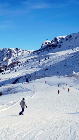 View of a ski resort piste with people skiing in Dolomites in Italy
