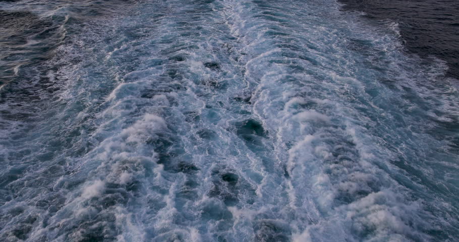 Ocean wake behind cruise ship Mediterranean Sea afternoon. Destination vacation travel European ocean sea. Mediterranean cruise ship wake behind boat. Beautiful blue Europe Ocean water wake.