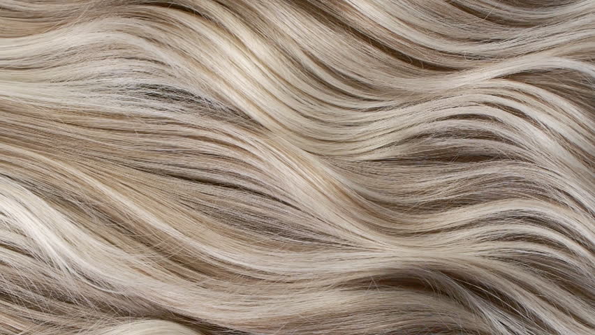 Closeup blond hair texture, slow motion of female hand combing long curly hair