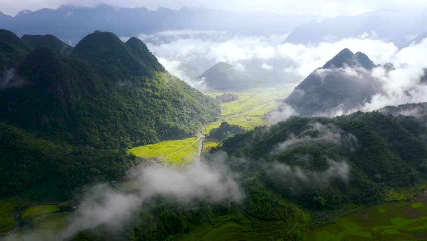 The landscape of the high mountain valley has golden terraced rice fields, clear blue sky, and sunshine