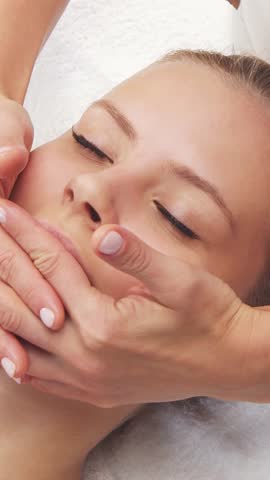 Woman is getting massage treatment from the therapist. Massaging procedure in spa. Healthcare, relaxation, rejuvenation and wellness concept.