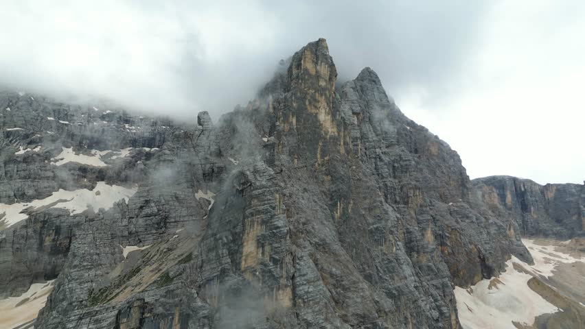 Impressive landscape of mountains covered in clouds in broad daylight.