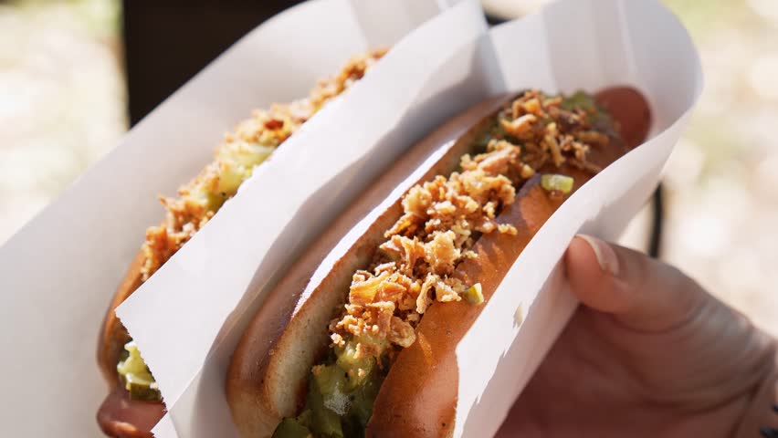 Appetizing hot dogs in hand. Close-up