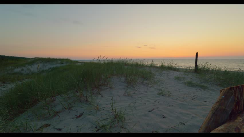 Beautiful orange sky over the sea. Beautiful sandy beach. Golden hour. Baltic Sea, Slajszewo, Poland