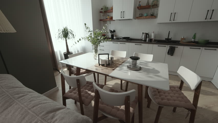 Open plan interior. Clean white kitchen in luxury modern contemporary home interior with living room. Scandinavian interior design with large windows. Dolly out camera movement