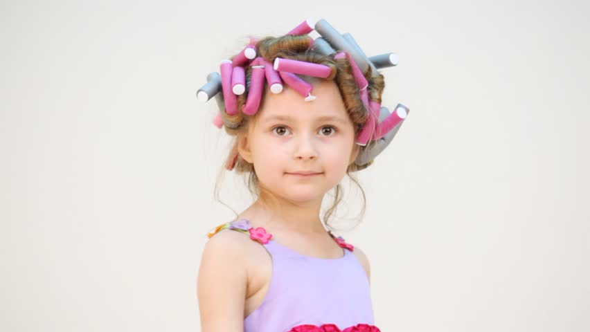 Cute little girl with hair roller in her hair