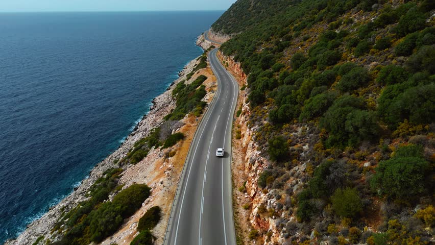 Scenic Coastal Road in Kas, Turkey with White Car - Drone Footage of Winding Cliffside Drive with Mediterranean Sea