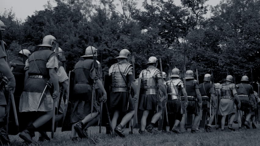 Roman soldiers in unity moving through a woodland trail, showing discipline and military strategy