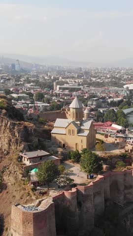 Drone footage of Tbilisi cityscape in summer, Georgia. Flying over the famous Narikala Fortress, old town, city center and Kura river in Tbilisi. Aerial view of the Georgian capital