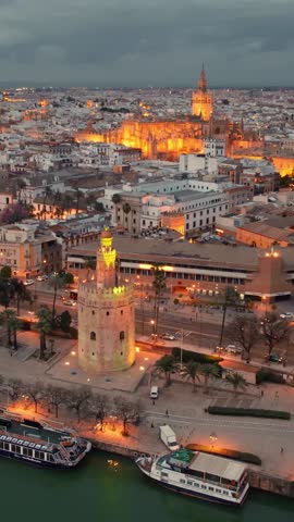 Seville cathedral at night, flying around the famous gothic Cathedral in Seville, Andalusia region, Spain. Aerial view of Seville Cathedral and Giralda bell tower. Andalusian capital drone footage