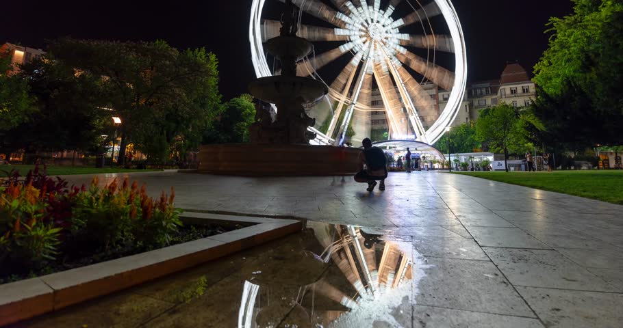 Budapest, Hungary: July 09, 2024: Ferris wheel on Elizabeth Square at night. Time-lapse, slide transition.