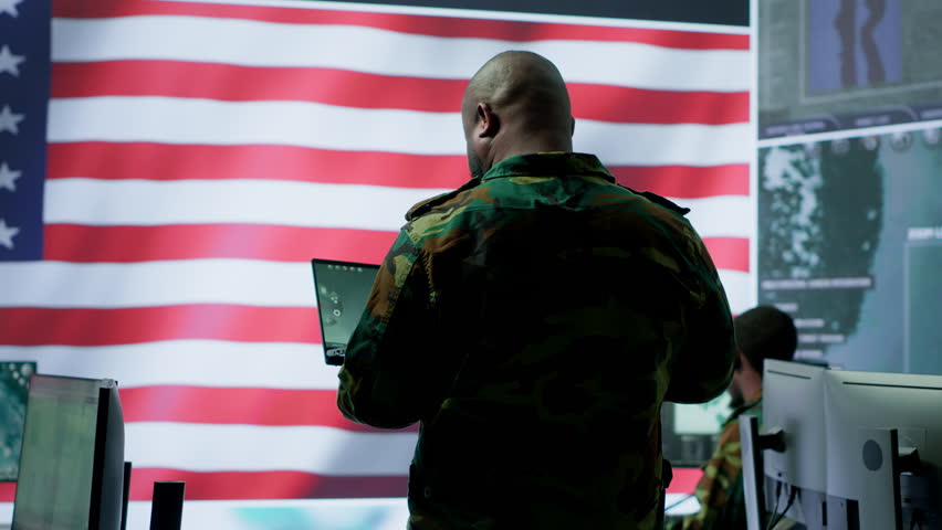 Team of military experts operates high tech computers and tablet to analyze surveillance data and manage national security operations. Working with CCTV radar satellite imagery. Camera A.