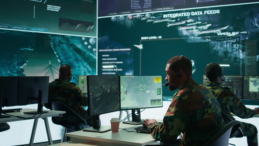 Soldiers in a state of the art military control room collaborate on data analysis, intelligence gathering, and mission planning. Ensure effectiveness and security of military operations. Camera B.