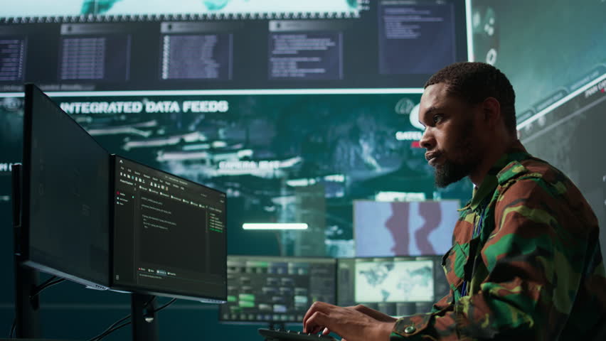 Military professionals in a mission control center employs modern technology to analyze satellite imagery and data, tracking threats and support intelligence operations. Surveillance system. Camera B.