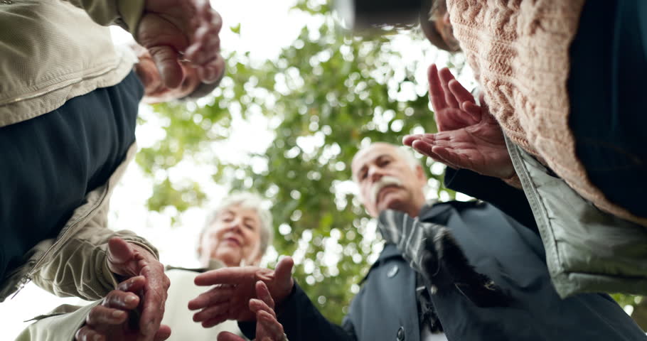 Nature, holding hands and senior people praying for religion, worship or spiritual belief. Hope, group and elderly friends with prayer together for retirement blessing or gratitude in park from below